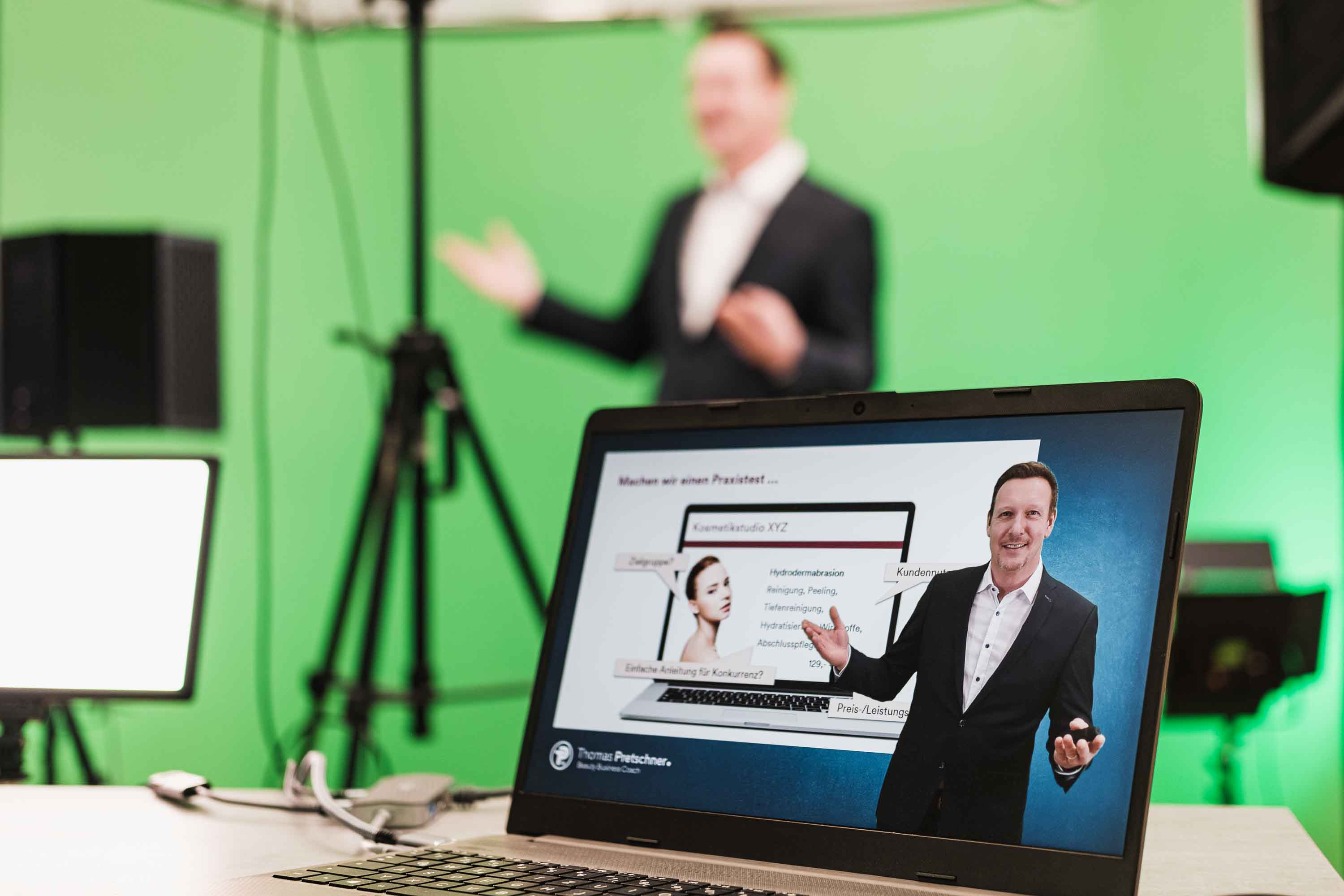 Thomas Pretschner bei einer Onlinepräsentation im Studio, sichtbar auf einem Laptop.